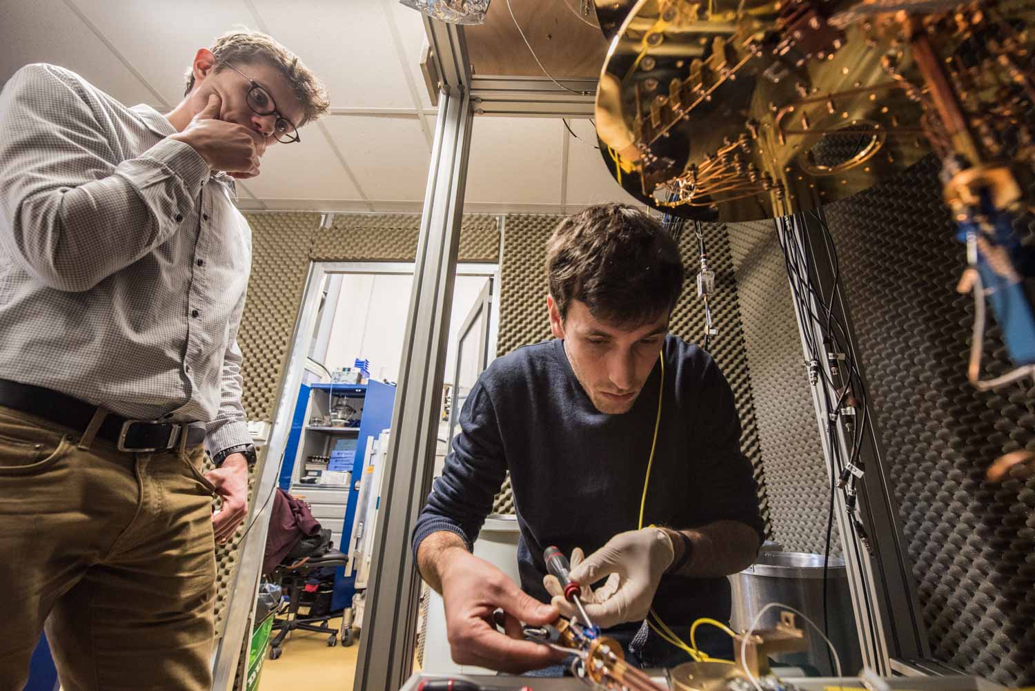 ENS, Département de physique, LPA. Laboratoire Pierre Aigrin . recherche sur les circuits quantiques hybrides. Tino Cubaynes doctorant et Mathieu Delbecq chercheur. Tino conduit un expérience de physique quantique pour laquelle il utilise des circuits de nanotubes de carbone. Mathieu supervise les opérations et lui apporte son aide et son expertise. Tino est en train de connecter son échantillon contenant les circuits de nanotubes de carbone au circuit du cryostat qui va héberger l'expérience.